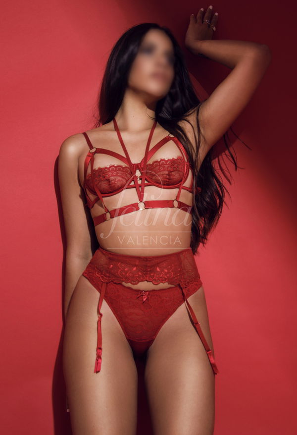 Escort latina en lencería roja sexy para masaje erótico en el burdel Felina Valencia
